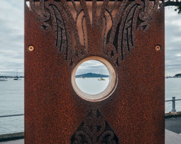 A pou on Tāmaki Drive, one of six by artist Graham Tipene, with a viewing portal to see Rangitoto. Image via Auckland Transport.